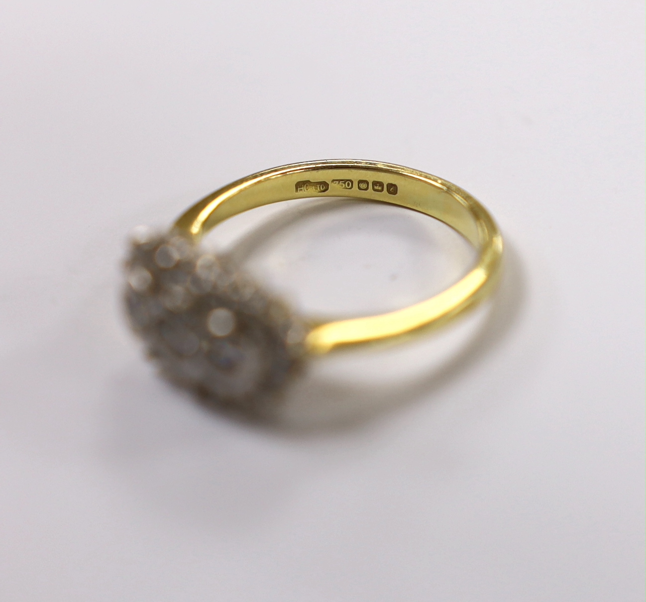 A modern 18ct gold and collet set three stone diamond ring, with diamond chip set border, size J/K, gross weight 4.6 grams.